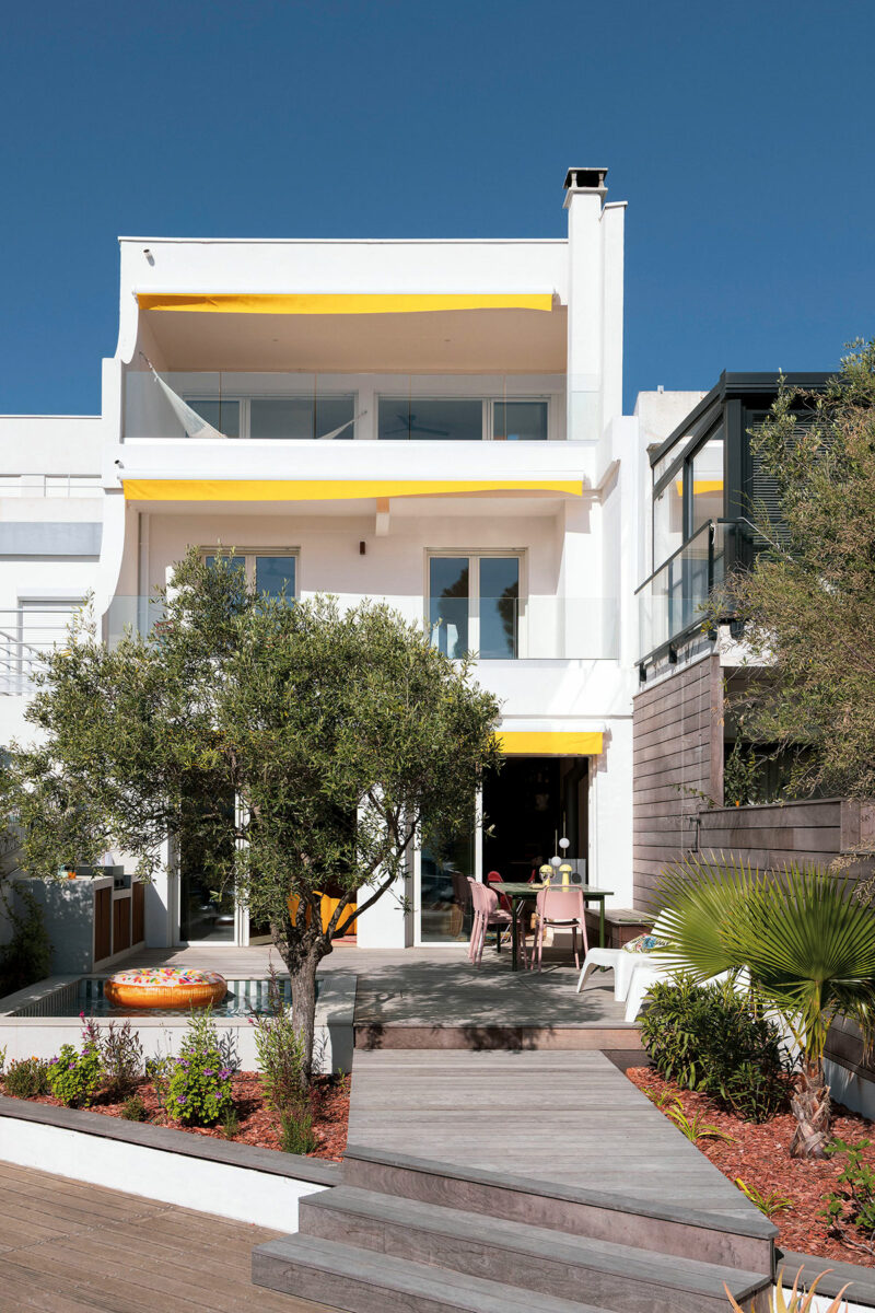 Façade blanche de la marina de Port Camargue avec ses stores jaunes, l’olivier, la terrasse en bois et la mini piscine