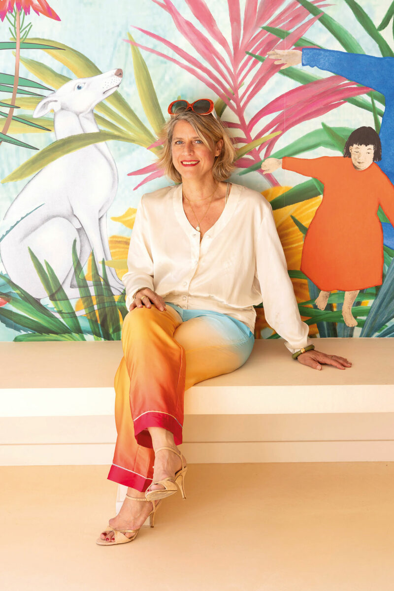 Portrait assis sur la banquette maçonnée devant la fresque murale du salon